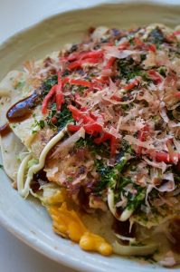 Okonomiyaki (お好み焼き) is another Japanese street food, like Yakisoba which I posted few weeks ago. The batter with loads of shredded cabbage is pan fried with egg, sliced meat, bonito flakes on top. Drizzle sweet Worcestershire sauce, mayonnaise and sprinkle aonori (青のり, green seaweed flakes) and benishoga (紅しょが, red pickled ginger) over it to make it a complete okonomiyaki.