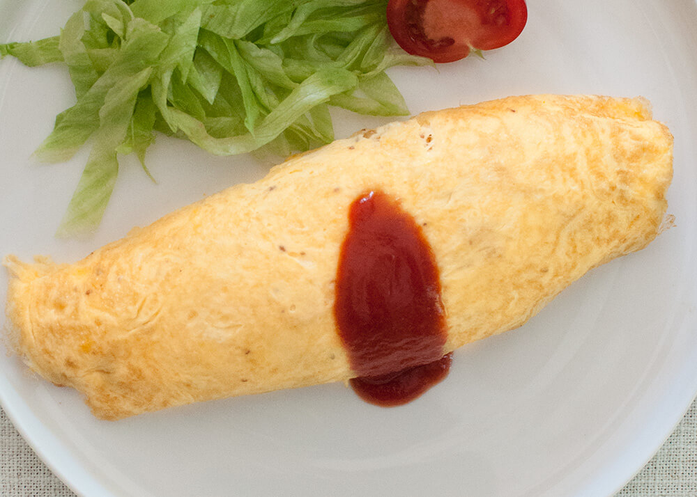 Japanese kids’ favourite dish, omurice (Japanese Rice Omelette) is another Western-influenced Japanese dish. It is basically an omelette with ketchup-flavoured chicken fried rice inside it.