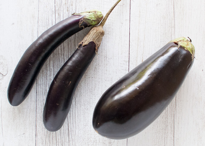 Thin long (small) eggplants and a large eggplant.