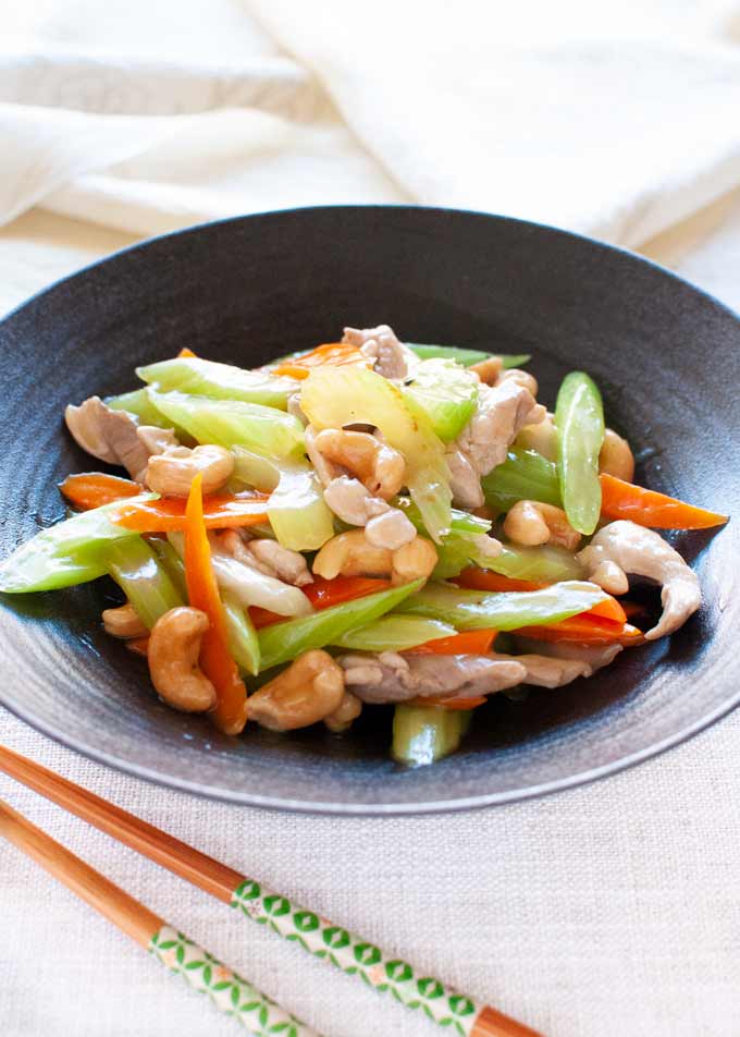 Chicken Stir Fry with Celery, Carrot and Cashew served on a black plate.