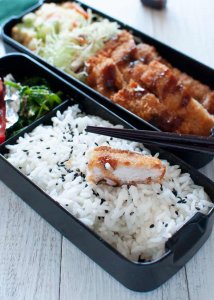 Tonkatsu Bento with a piece of half bitten tonkatsu on the rice.