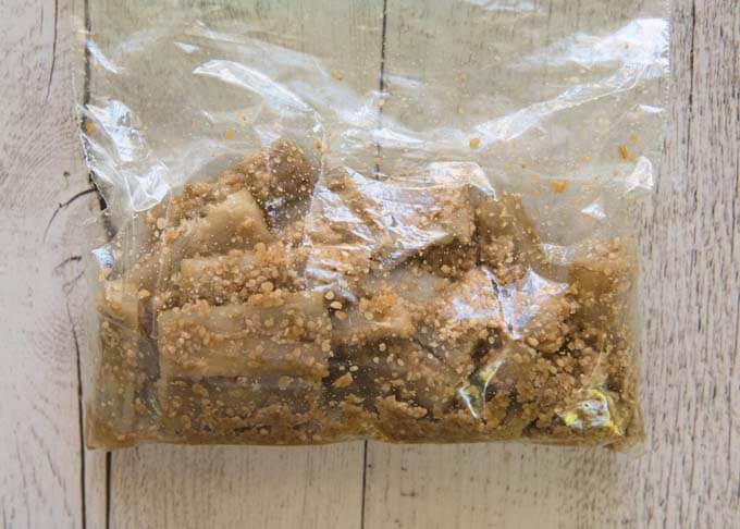 Burdock pieces dressed in sesame dressing and kept in a plastic bag.