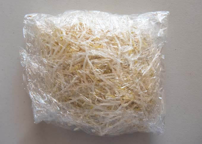 Bean sprouts wrapped in cling wrap, ready to be steamed in microwave.