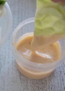 A piece of cabbage dipping into Miso Dip.