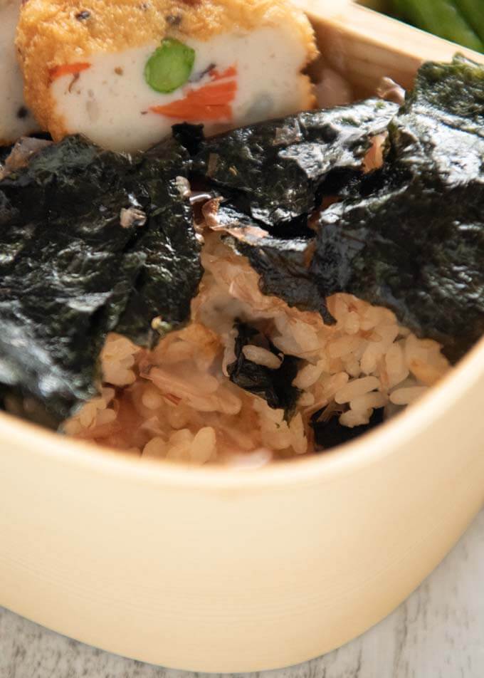 Zeeomed-in photo of the rice showing layered nori and bonito flakes.