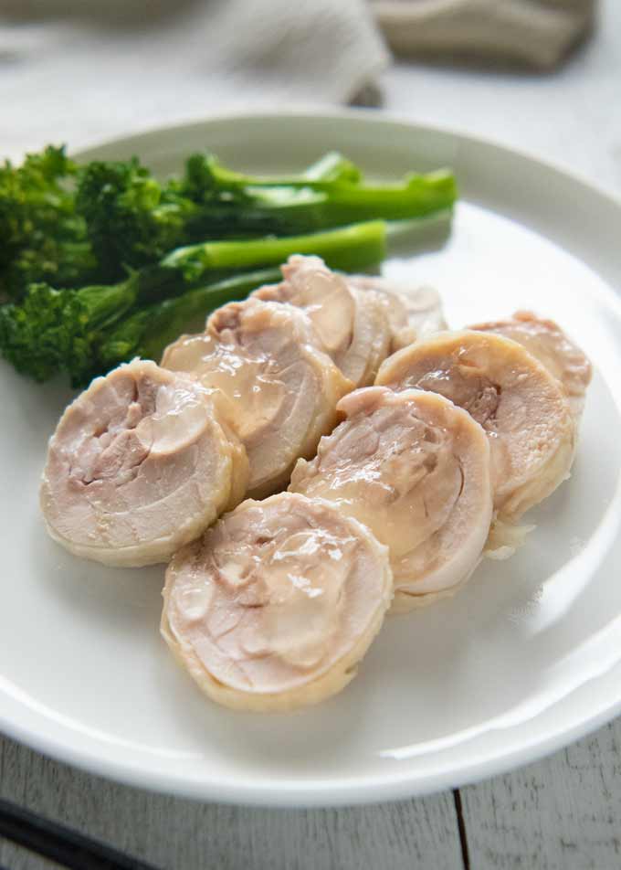 Hero shot of Salty Chicken Rolls on a servng plate with blanched broccolini.