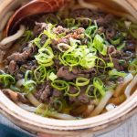 Beef udon noodle soup in a serving bowl.