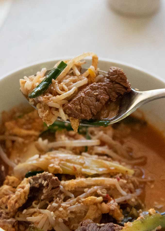 Zoomed-in photo of Korean Beef Soup with Rice, scooping with a spoon.