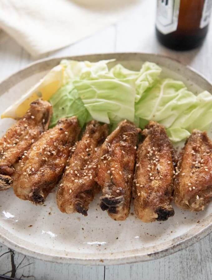 Hero shot of Furaibou-style fried chciken wings on a plate served with cabbage pieces.