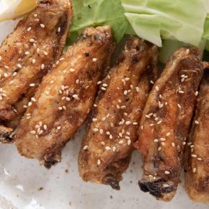 Hero shot of Furaibou-style fried chciken wings on a plate served with cabbage pieces.