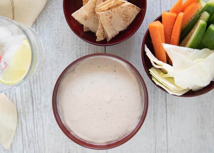 Top-down photo of Anchovy and Tofu dip served with vegetables and crisps.