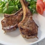 Hero shot of Pan-Fried Lamb Chops with Miso Marinade served with salad and tomato wedges.
