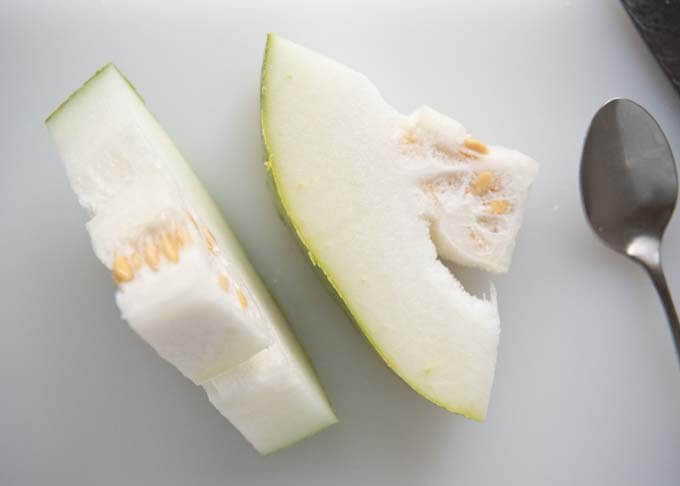 Sliced winter melon showing seeds and soft fluffy flesh.