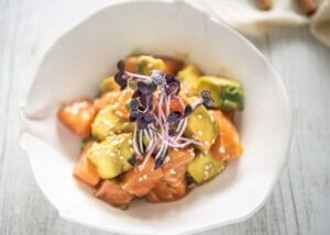 Salmon and Avocado in Wasabi Soy Dressing with red radish microgreens as garnish.