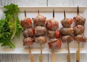 Top-down photo of Grilled Mini Tomatoes Wrapped in Pork.