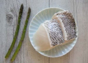 The fish fillets to be marinated and 2 spears of asparagus for garnish.