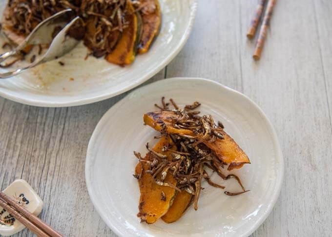 Taking some Sautéed Pumpkin with Crunchy Baby Anchovies onto an individual serving plate.